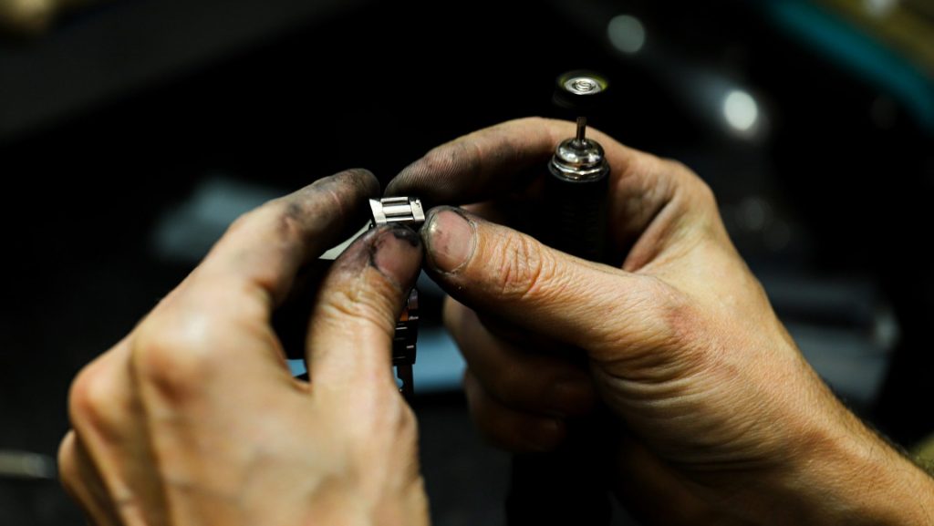 a man is working on a piece of metal