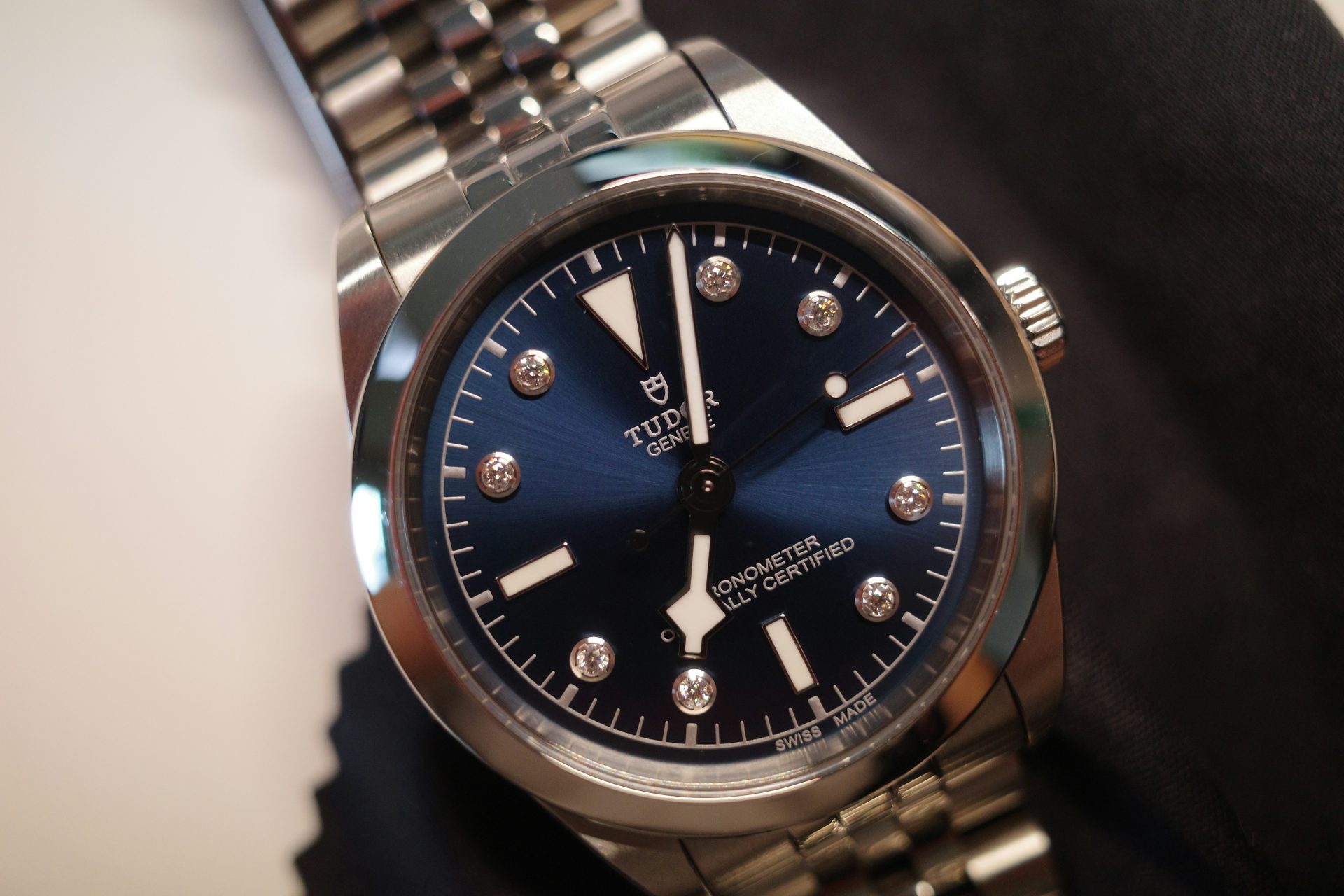 A watch sitting on top of a metal bracelet